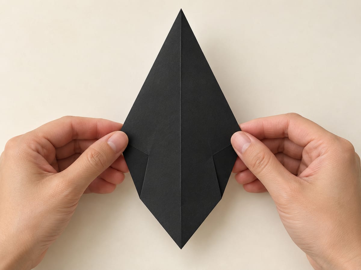 origami penguin step 3: turn the paper over, keeping the long point at the top, hands visible
