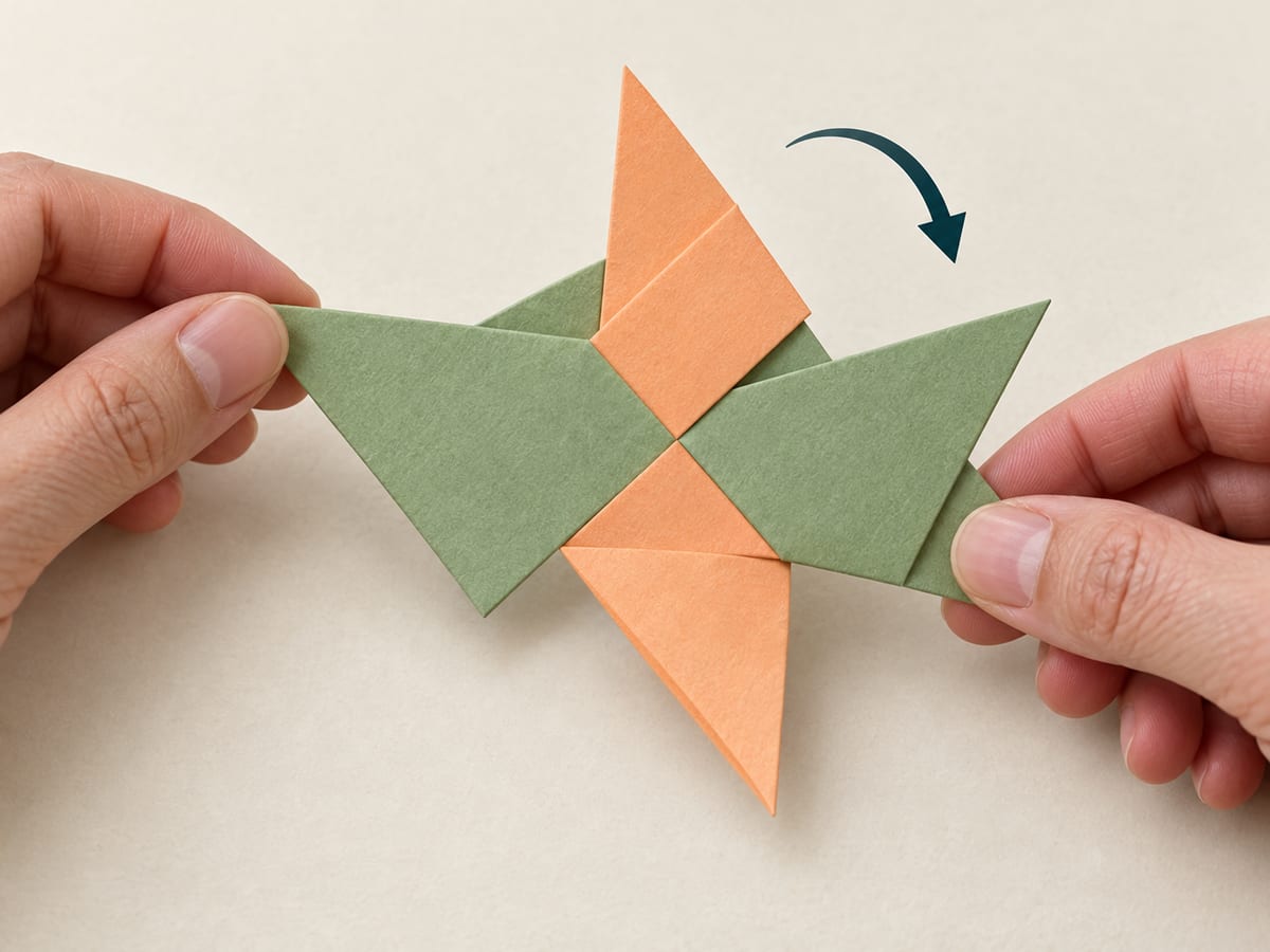 origami ninja star step 11: turn the joined pieces over carefully, keeping the first two tucks in place, hands visible