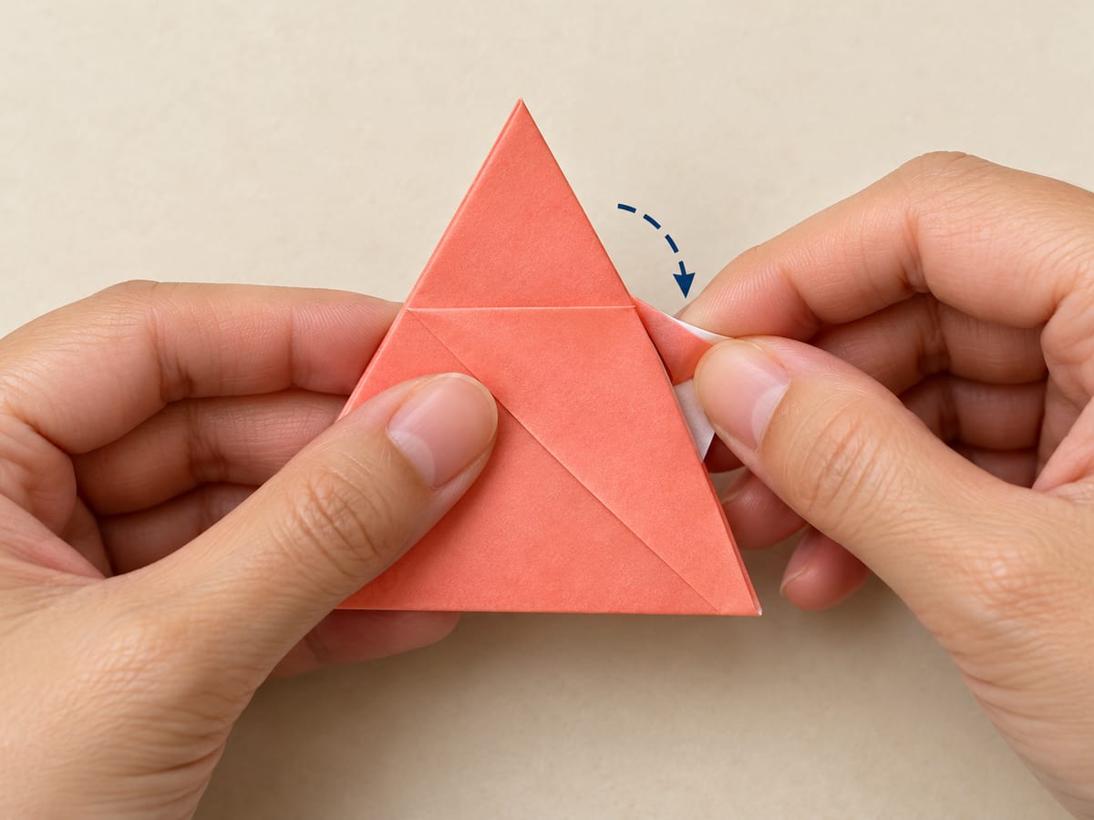 origami star step 5: tuck the short leftover end between the triangle layers, then turn one corner upward, hands visible