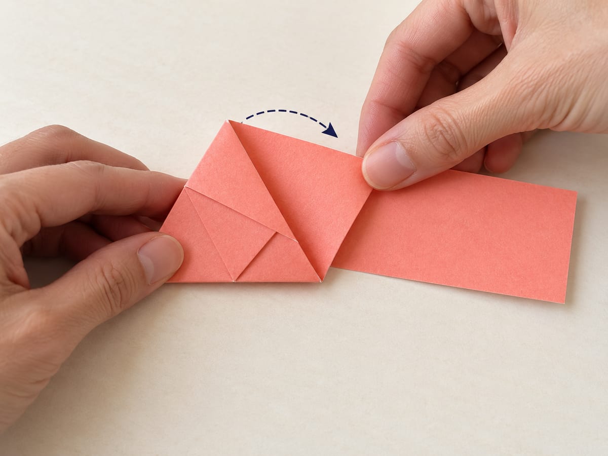 origami star step 4: roll the triangle rightward along its edge, wrapping the remaining length around the triangular face, hands visible