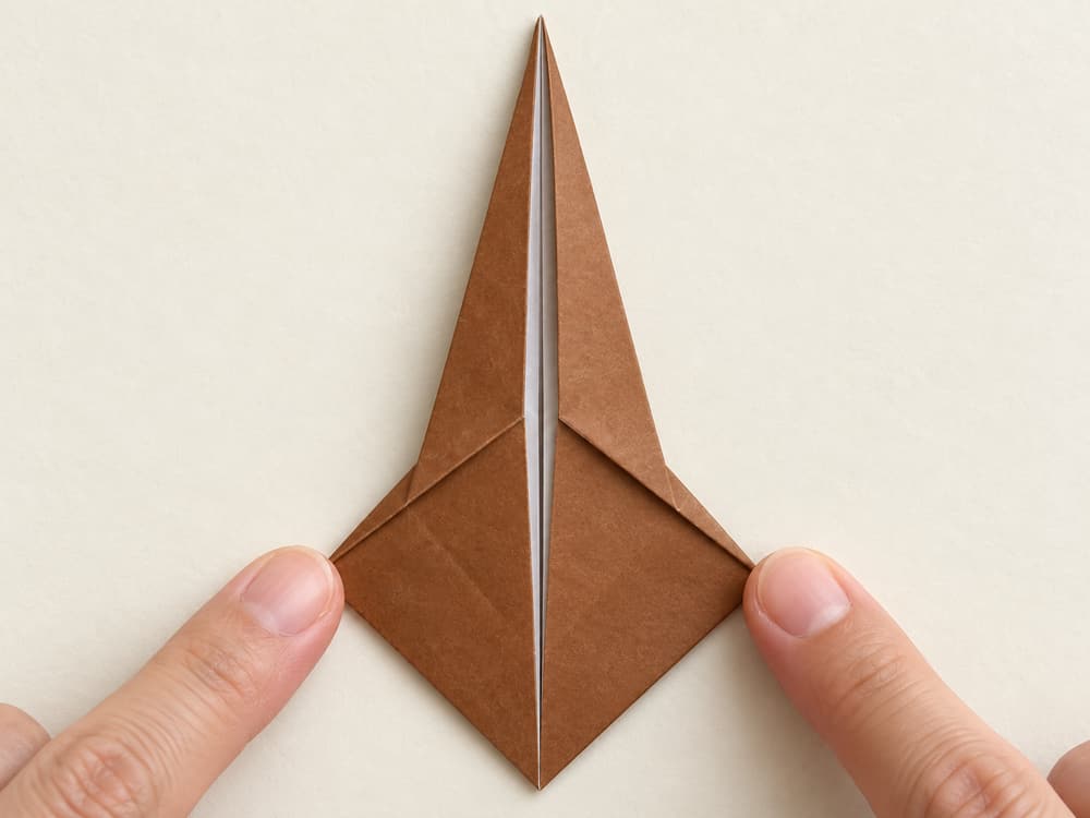 origami turkey step 3: fold the two upper sloping edges to the center once more, hands visible
