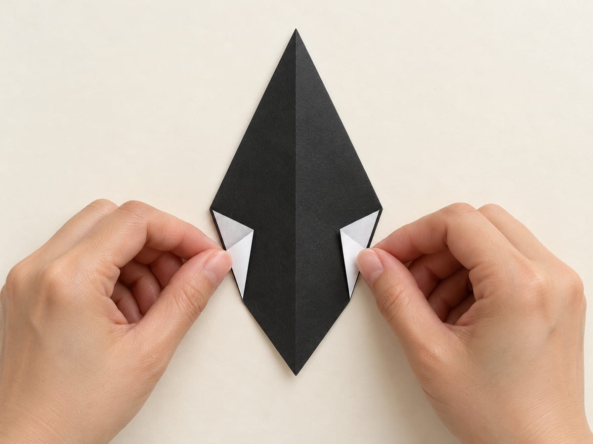 origami penguin step 4: fold the left and right side corners inward to make the body narrower below its shoulders, hands visible