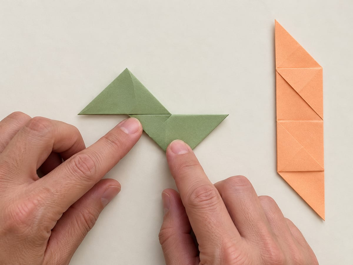 origami ninja star step 7: fold its lower half diagonally leftward, making a compact zigzag with two pointed arms, hands visible