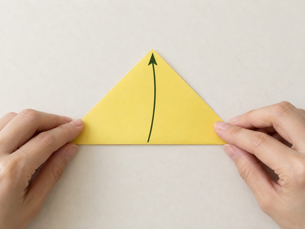 origami bookmark step 1: place the square as a diamond; bring the bottom corner to the top corner and crease, hands visible