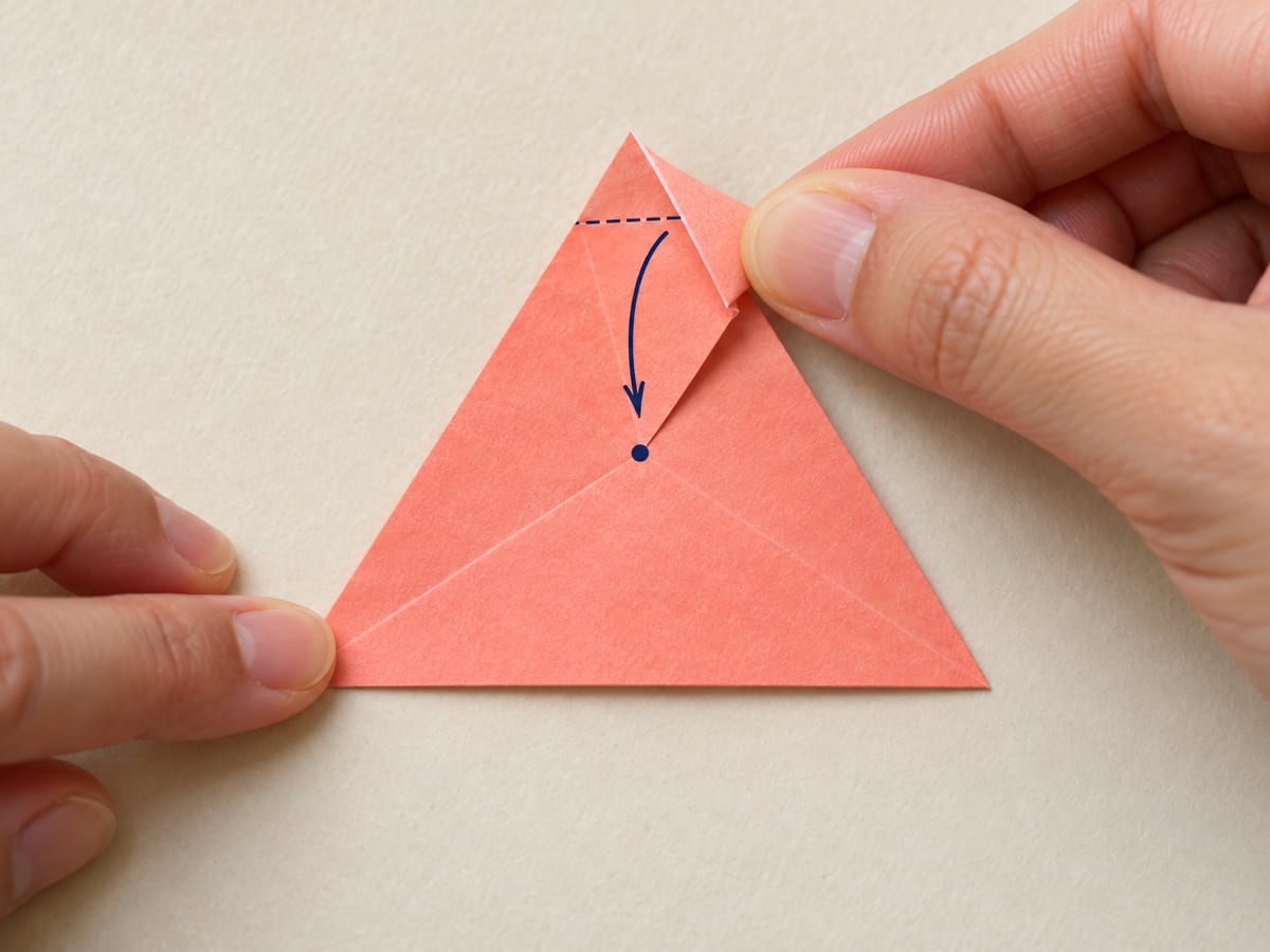 origami star step 9: fold each corner to the center where the guide lines meet; crease and reopen all three, hands visible